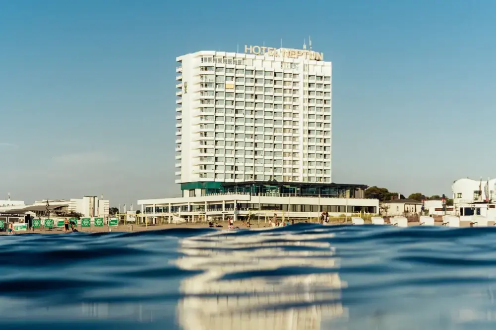 Modernes Hochhaushotel direkt am Wasser mit klarem blauen Himmel im Hintergrund