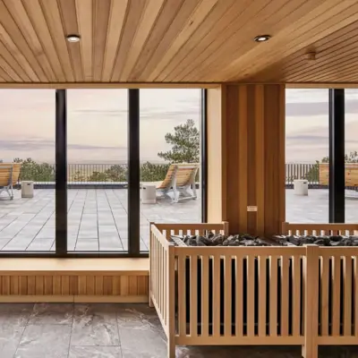 Eine lichtdurchflutete Sauna im Urban NAture Hotel St. Peter-Ording mit Blick auf eine große Außenterrasse und die Nordsee.