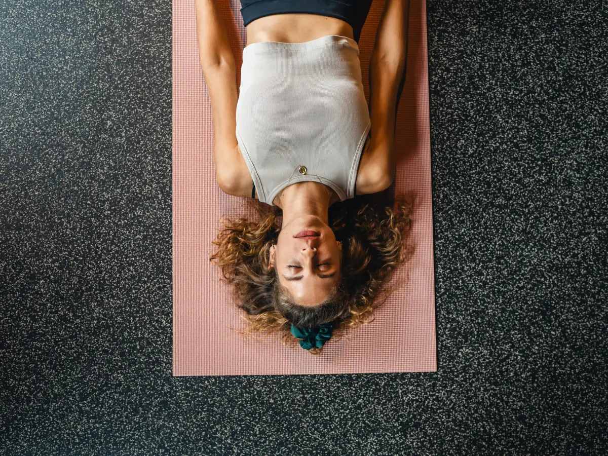 Yoga Urban Nature St. Peter-Ording Eine Frau liegt auf einer Yogamatte.