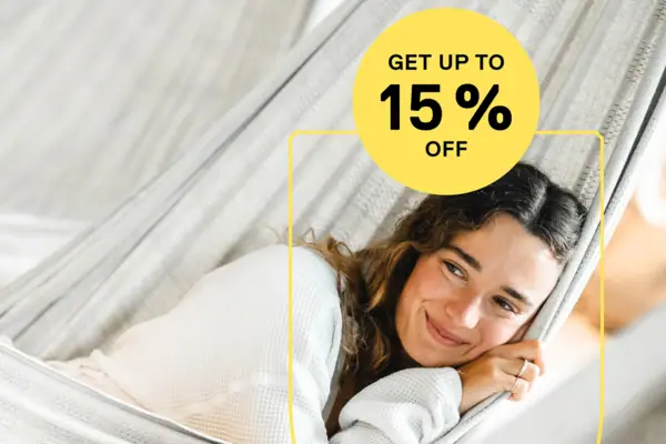 Low Season Deal Eine Frau liegt lächelnd in einer Hängematte.