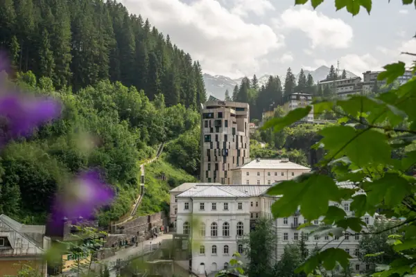 Urban Nature Hotel Bad Gastein Das Urban Nature Hotel Bad Gastein mit Bergen und Bäumen im Hintergrund.