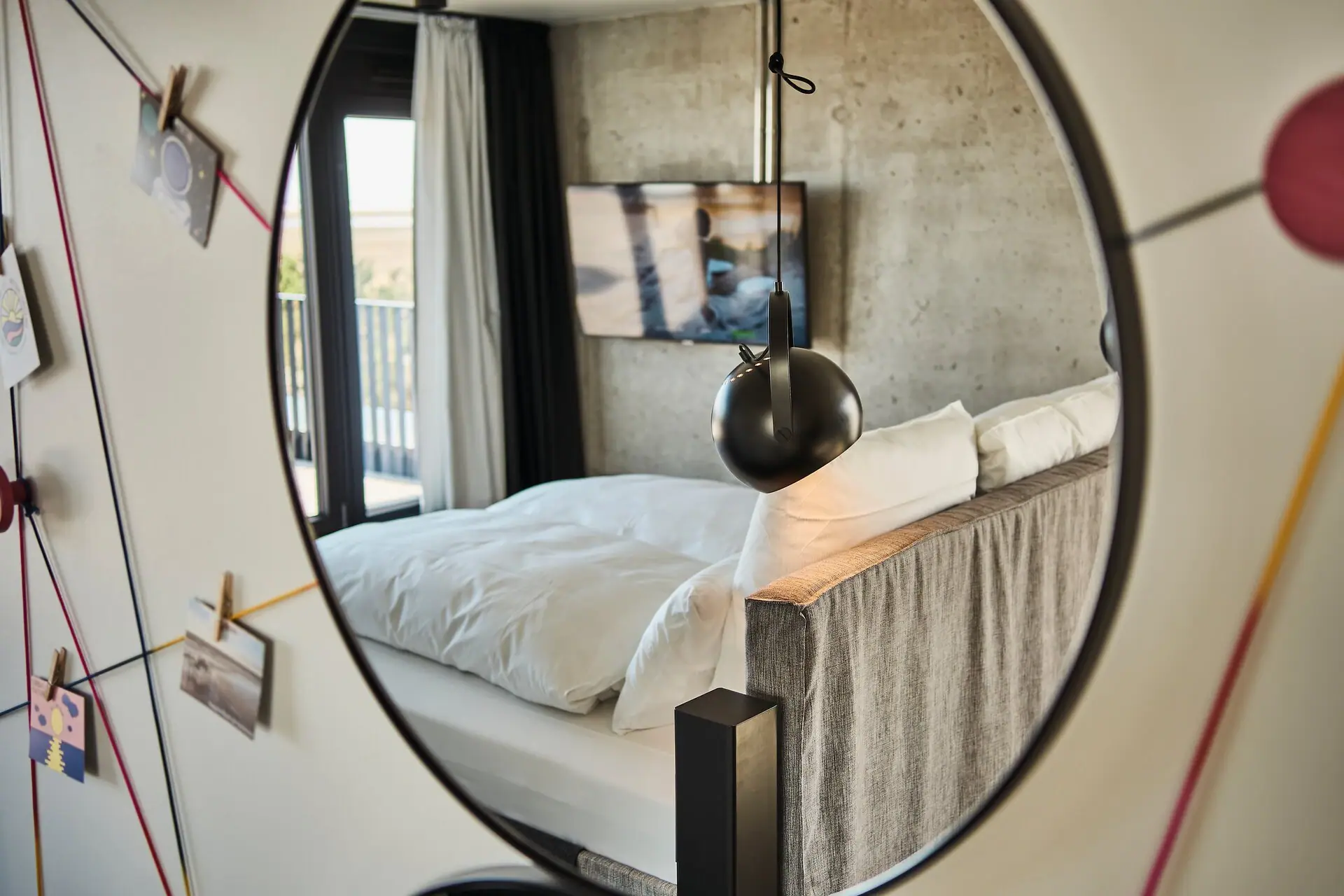 Spiegel in einem Schlafzimmer mit Bett und Bettwäsche.