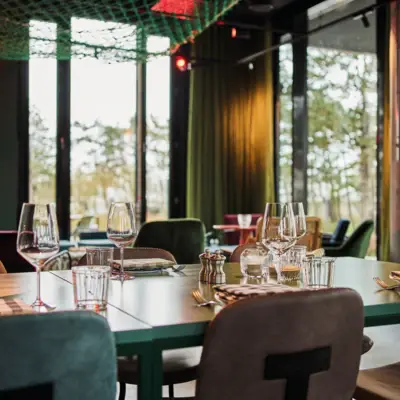 Ein gedeckter Tisch im Restaurant mit verschiedenen Gläsern und Besteck.
