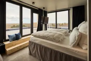 Suite Eine Suite im Urban Nature Hotel St. Peter-Ording mit großen Fenstern und einer großen Terrasse.