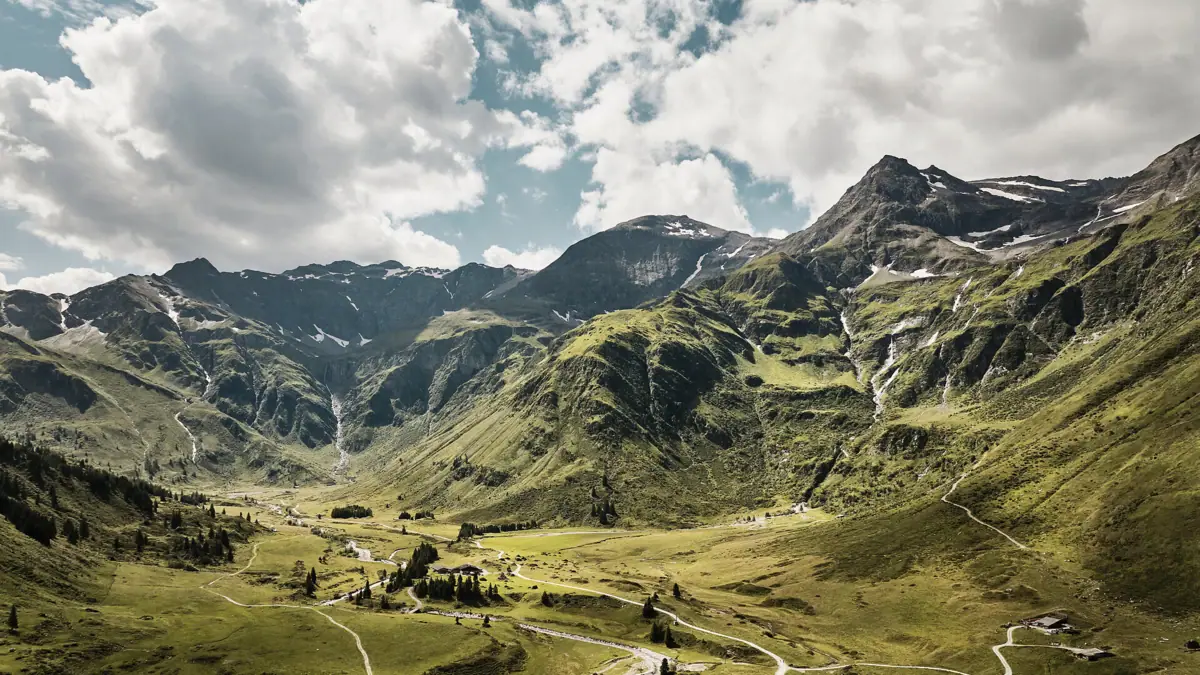 Umgebung von Bad Gastein Eine kurvenreiche Straße durch ein Tal mit Bergen im Hintergrund.