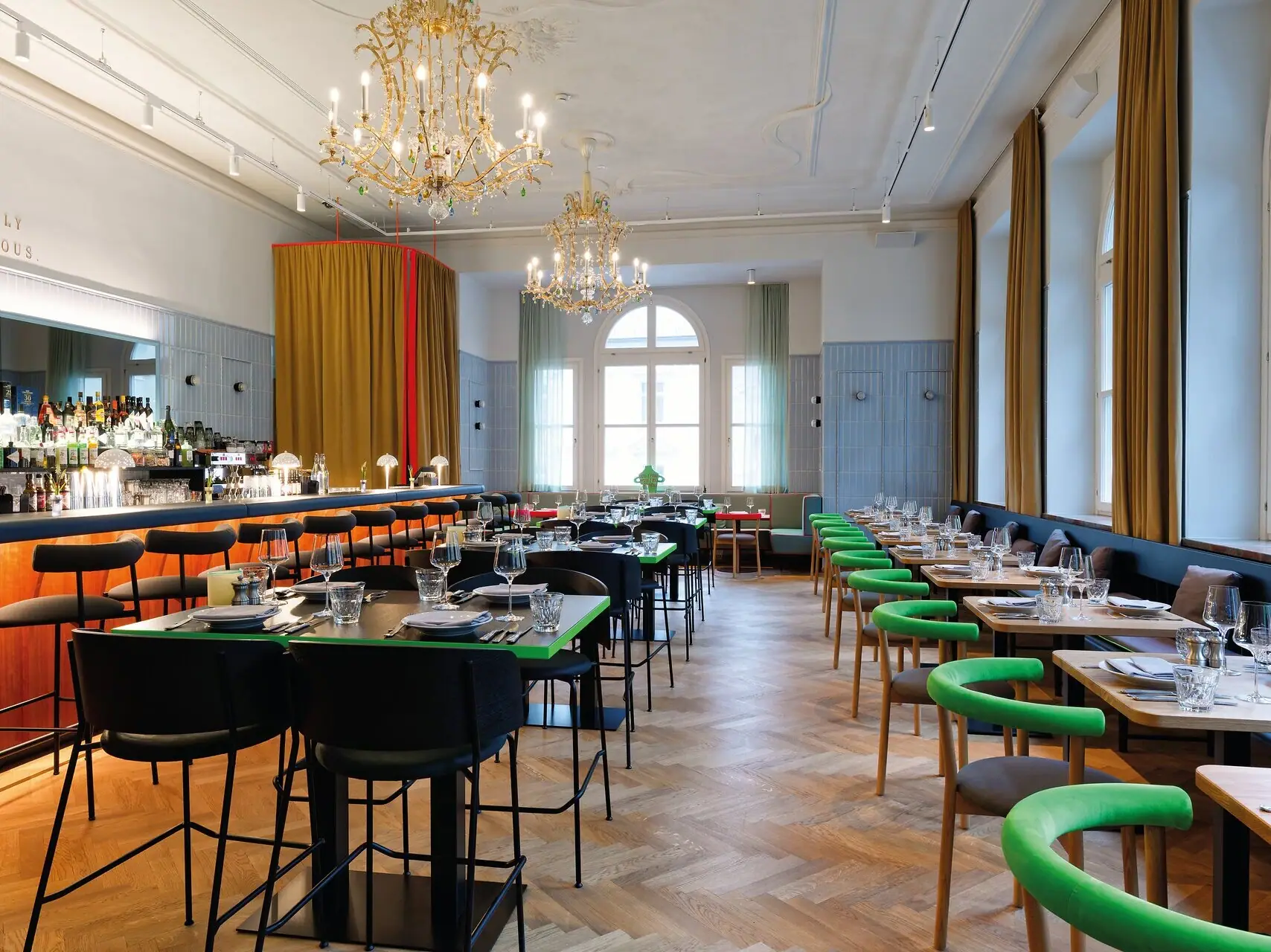 Ein Restaurant mit Tischen und Stühlen sowie einer Bar Theke auf der linken Seite.