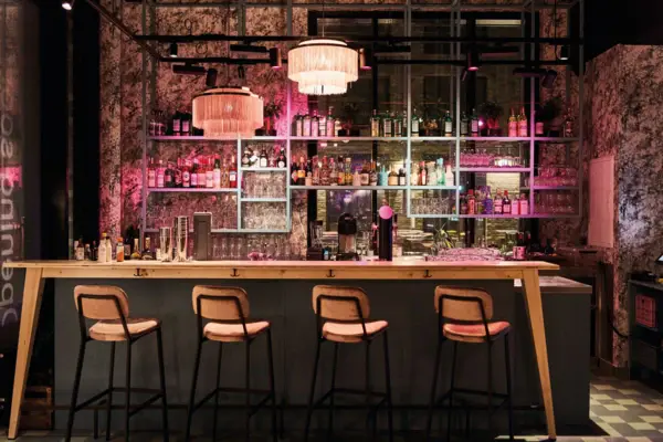 Eine Bar mit einer Reihe von Hockern und Lichtern.