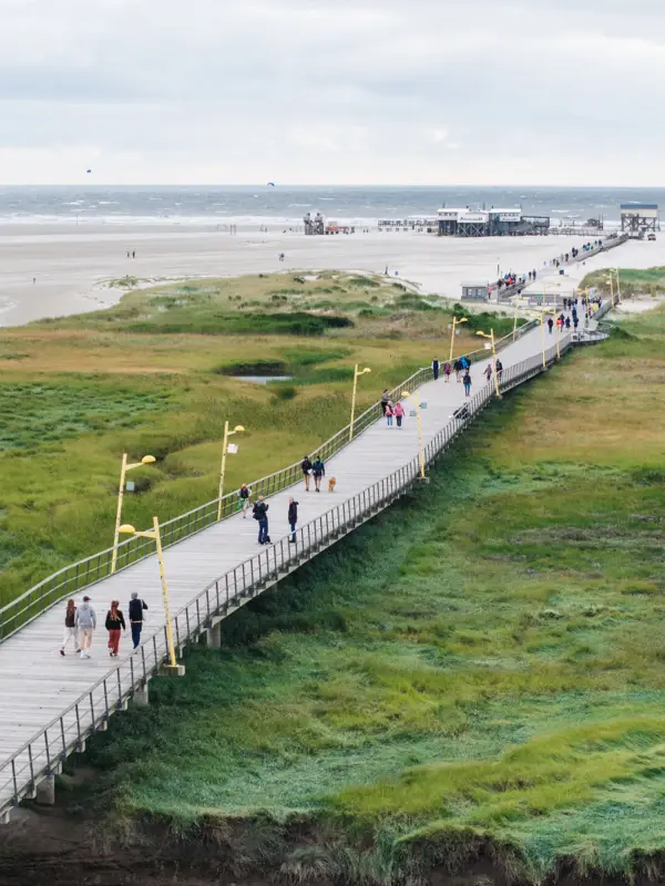 Die Seebrücke in St. Peter-Ording, die über die Salzwiesen bis zum Strand führt von oben fotografiert.