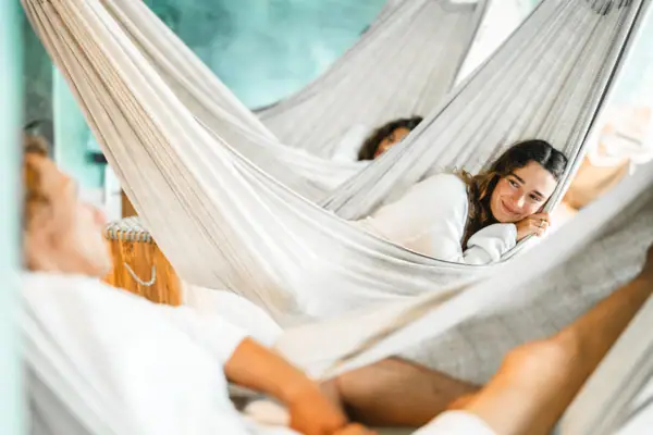 Mehrere Menschen liegen in Hängematten und entspannen.
