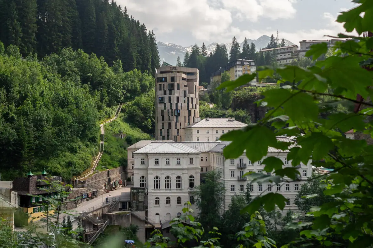 Eine Gruppe von Gebäuden im Wald unter bewölktem Himmel.