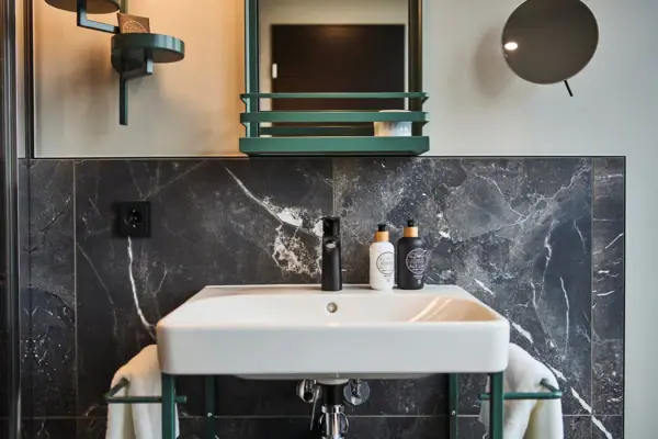 Badezimmer Ein Badezimmerwaschbecken mit einem Spiegel und einem Wasserhahn.