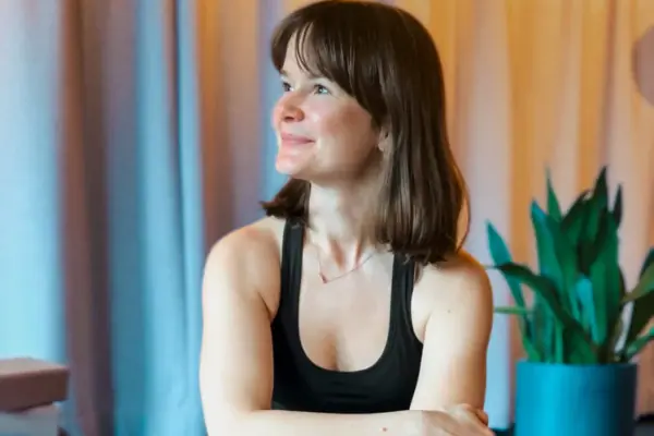 Eine Frau sitzt auf einer Yogamatte.