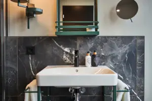 Badezimmer Ein Badezimmerwaschbecken mit einem Spiegel und einem Wasserhahn.
