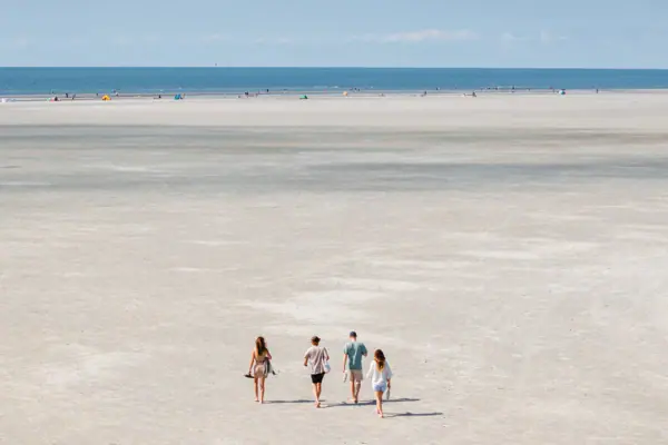 Eine Gruppe von Menschen, die am Strand spazieren geht.