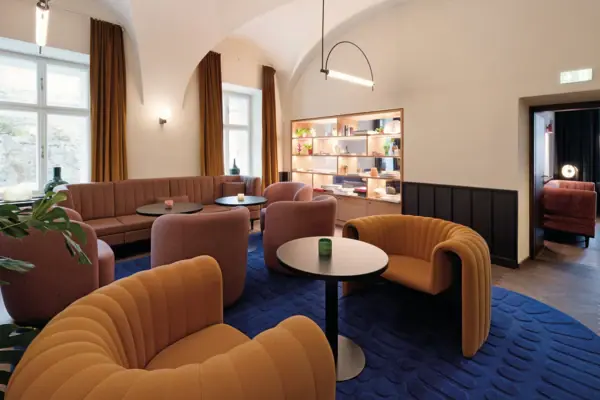Ein Raum mit einer Couch und Tischen im Urban Nature Hotel Bad Gastein.