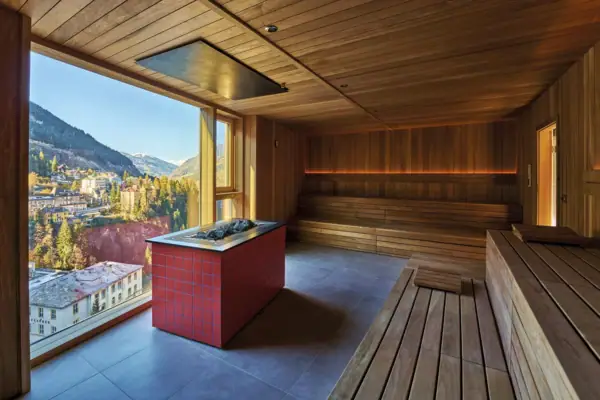 Moderne Sauna mit Panoramafenster und Ausblick auf Bad Gastein und die umliegende Bergwelt.