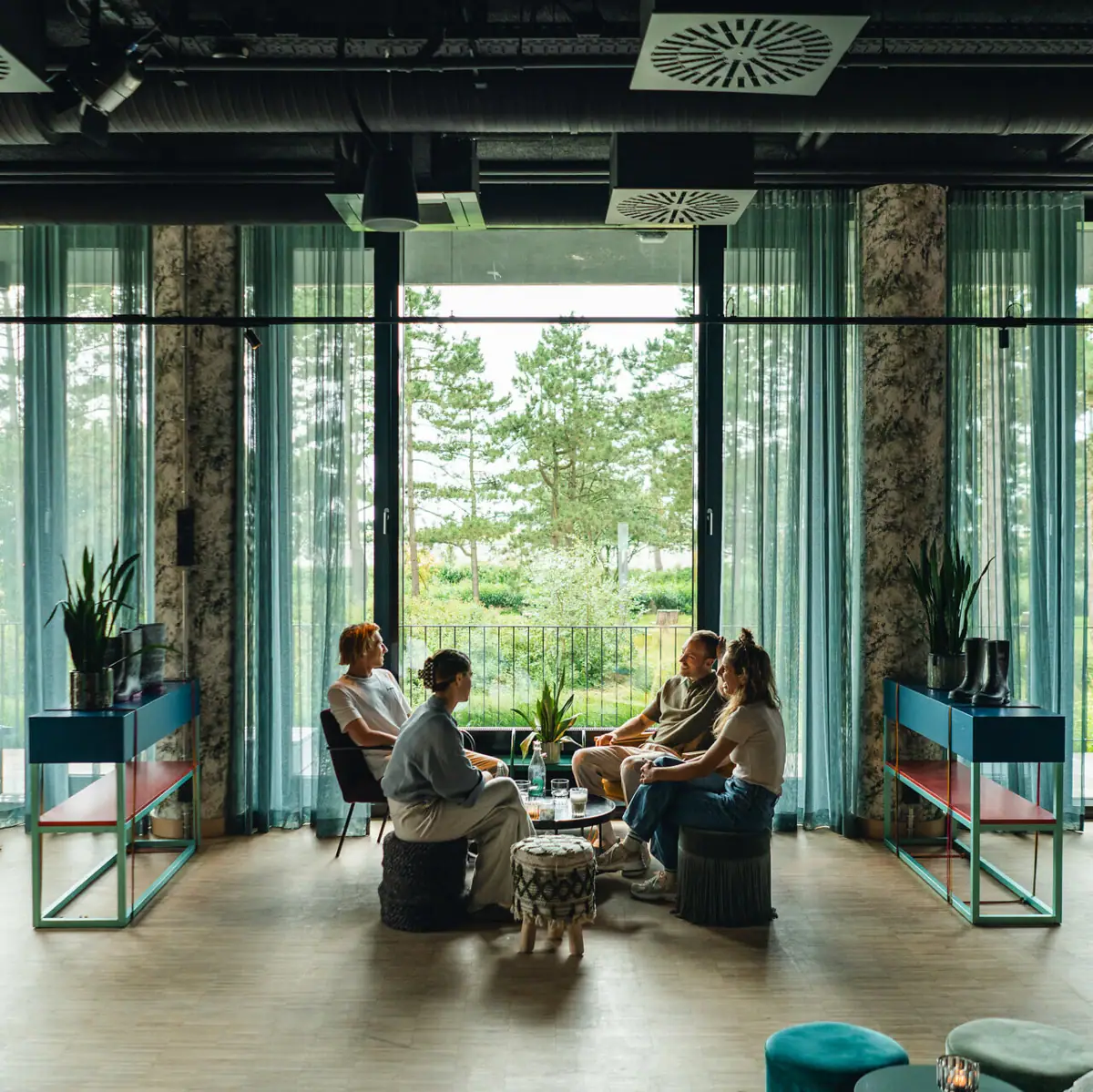 Gruppenreise ins Urban Nature Eine Gruppe von Menschen sitzt in einem Raum mit großen Fenstern.