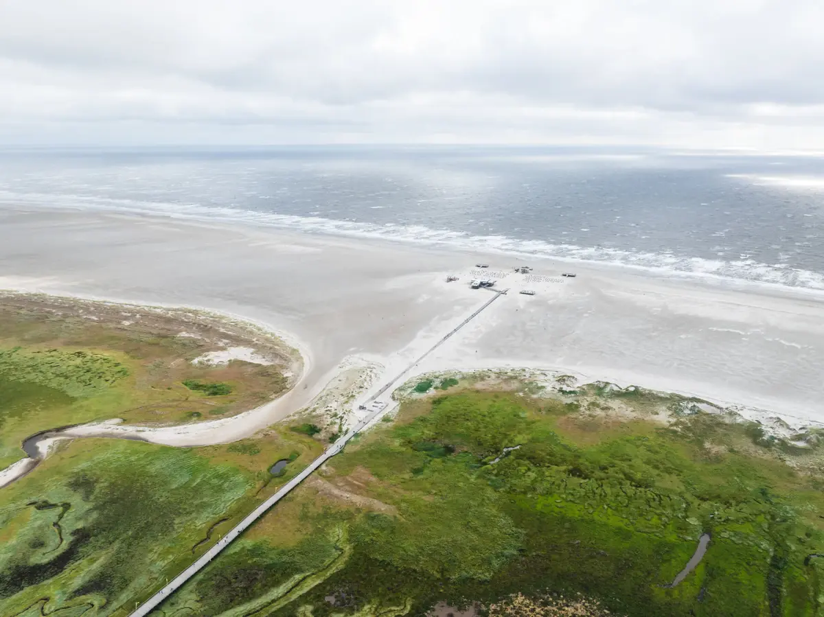 Der Strand von St. Peter-Ording mit der Seebrücke , die über die Salzwiesen zum Meer führt.