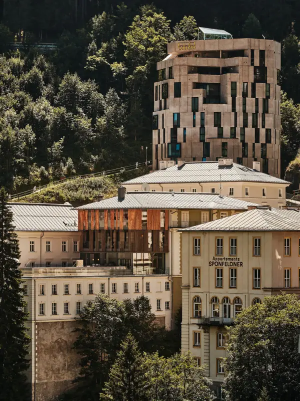Eine Außenansicht vom Urban Nature Hotel in Bad Gastein mit den Bergen im Hintergrund.