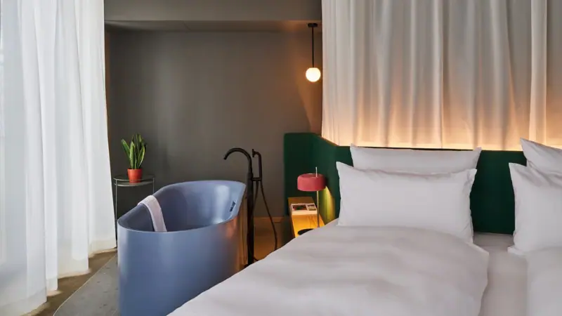 Ein Bett mit einer Badewanne und einer Lampe in einem stilvoll eingerichteten Raum.