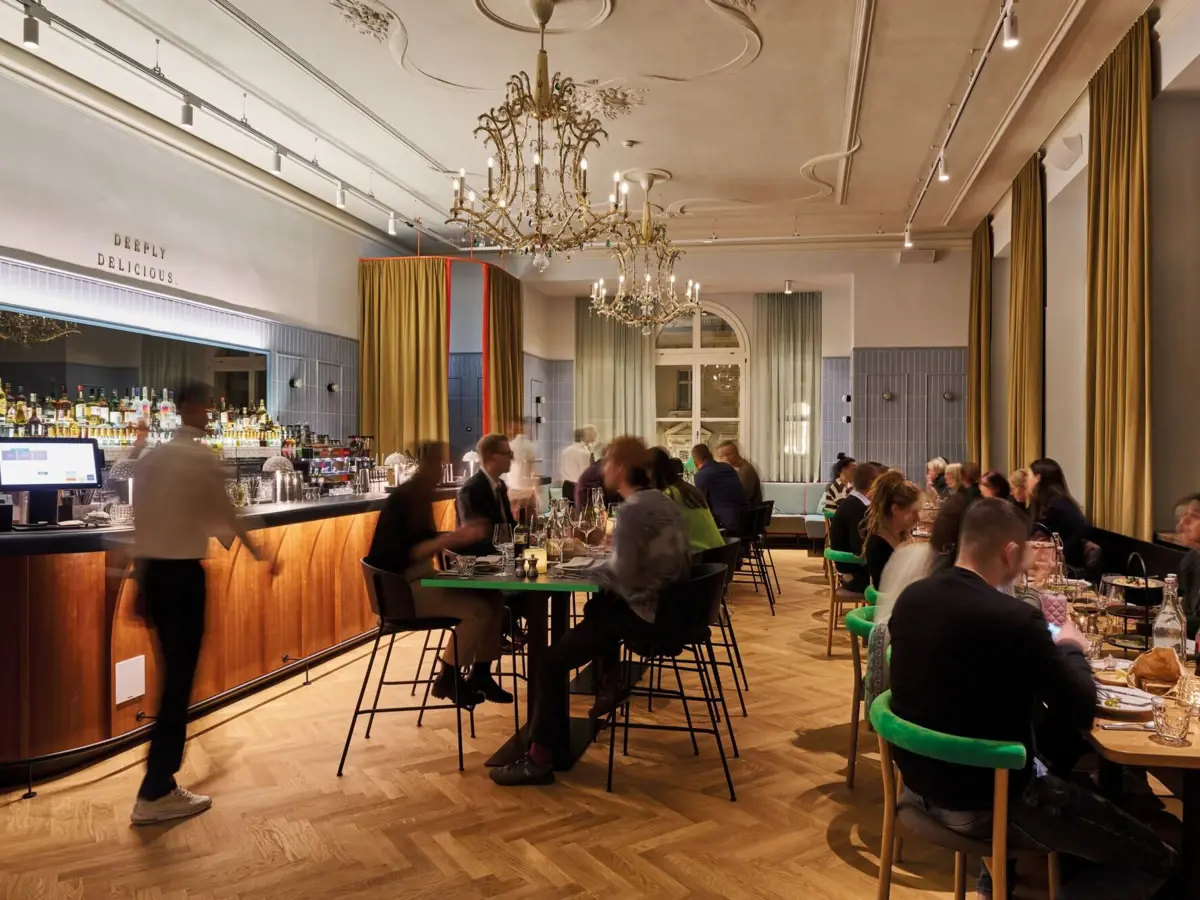 Urban Nature Bad Gastein In einem Restaurant sitzen viele Menschen an Tischen und auf der linken Seite ist eine Bar zu sehen.