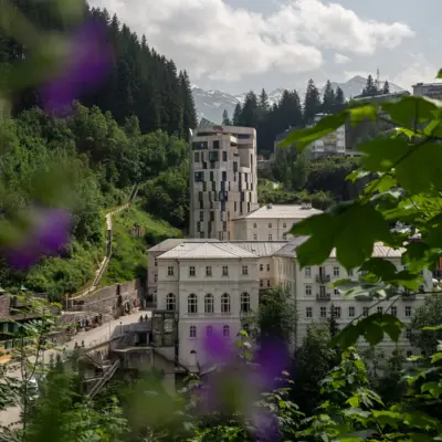 Alpine house in Bad Gastein at sunrise, set against rugged mountain scenery.