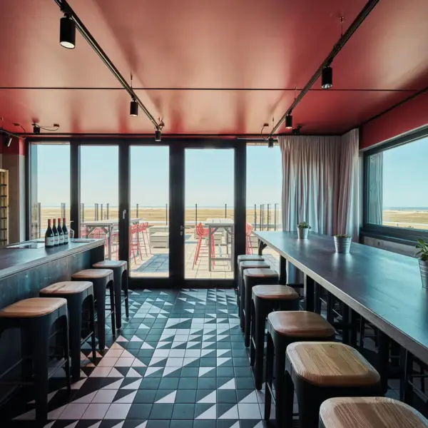 Eine Bar mit einer Reihe von Hockern und einer Dachterrasse im Hintergrund.