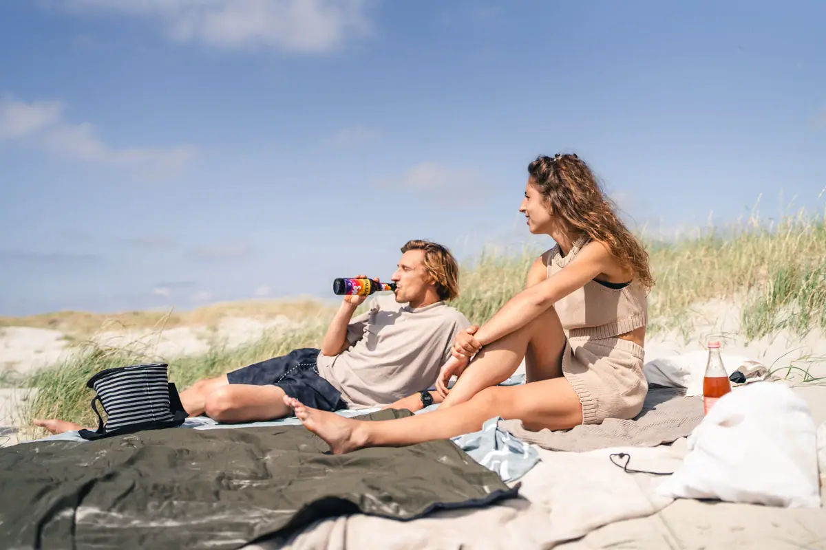 Strand von St. Peter-Ording Ein Mann und eine Frau sitzen auf einer Decke am Strand.