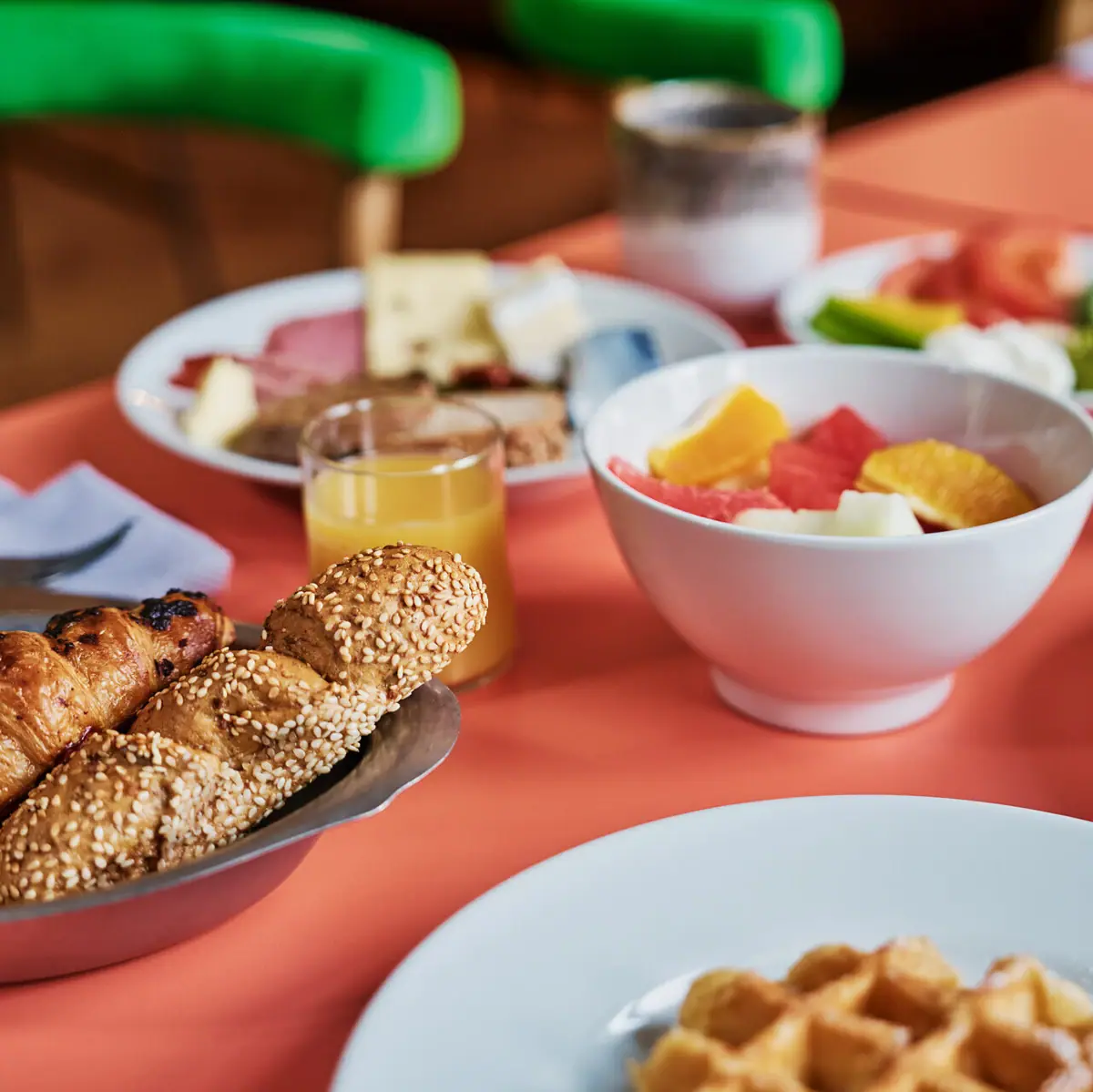 Frühstückstisch Auntie Heidi Ein Frühstückstisch mit Speisen wie Obst, Brot, Eiern und Orangensaft.