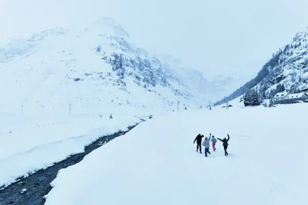 Eine Gruppe von Menschen geht im Schnee spazieren.