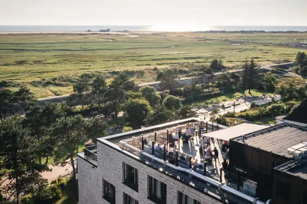 Urban Nature SPO Das Urban Nature Hotel St. Peter-Ording mit einer Gruppe von Menschen auf der Rooftop-Bar.