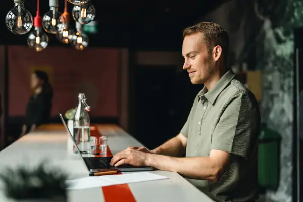 Ein Mann sitzt an einem Tisch und benutzt einen Laptop.