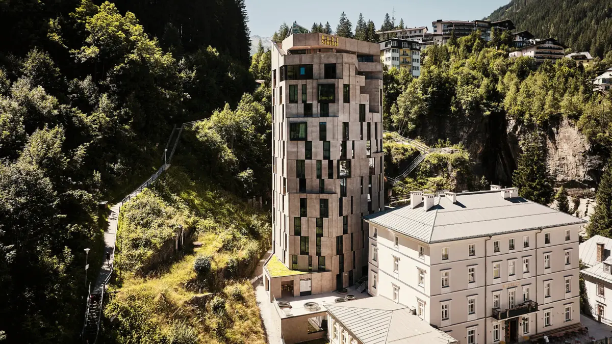 Außenansicht des Urban Nature Hotels im Badeschloss Bad Gastein Moderner Hotelturm mit einzigartiger Fassade inmitten der Berglandschaft von Bad Gastein – architektonisches Highlight neben dem historischen Hauptgebäude des Urban Nature Hotels im Badeschloss Bad Gastein