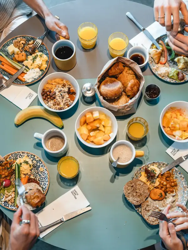 Ein Frühstückstisch mit Speisen wie Obst, Brot, Eiern und Orangensaft.