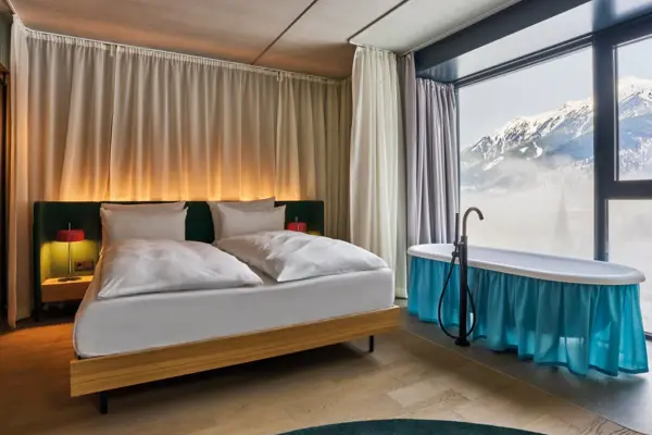 Ein modernes Hotelzimmer mit einem Bett und einer freistehenden Badewanne.