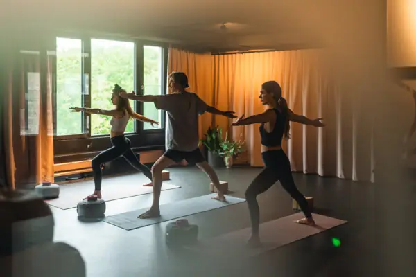 Eine Gruppe von Menschen beim Yoga auf Matten in einem Innenraum