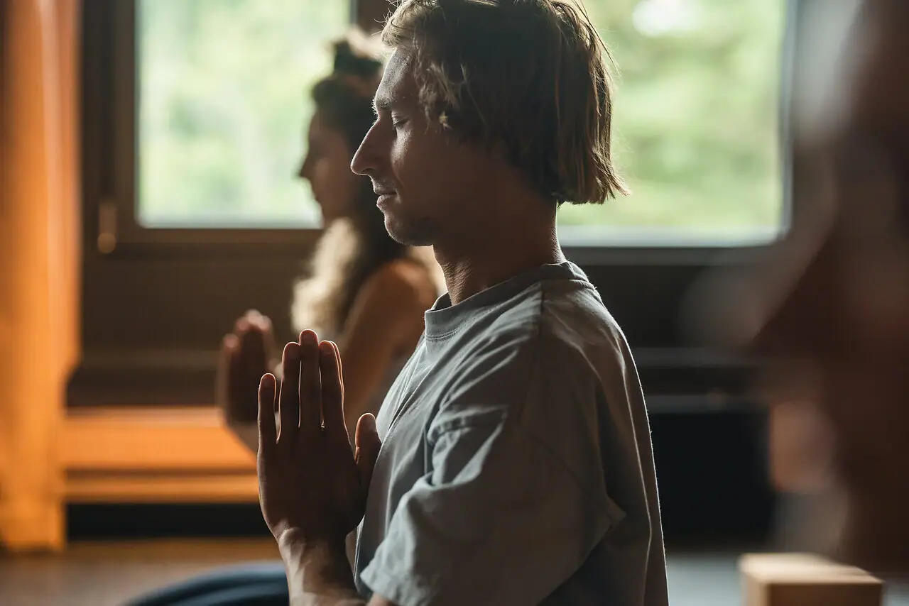 Ein Mann sitzt in einer Yoga-Pose.