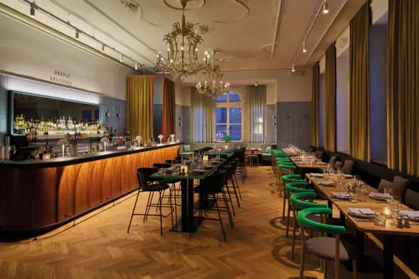 Stilvolles Restaurant mit eleganter Bar, Kronleuchtern, langen Tafeln und modernem Design