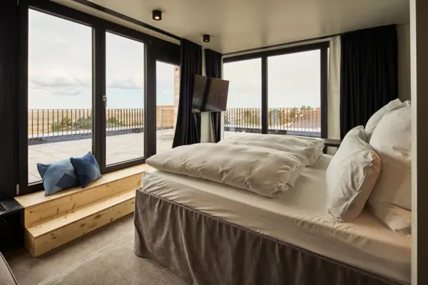 Schlafzimmer mit Fenster und Fernseher.