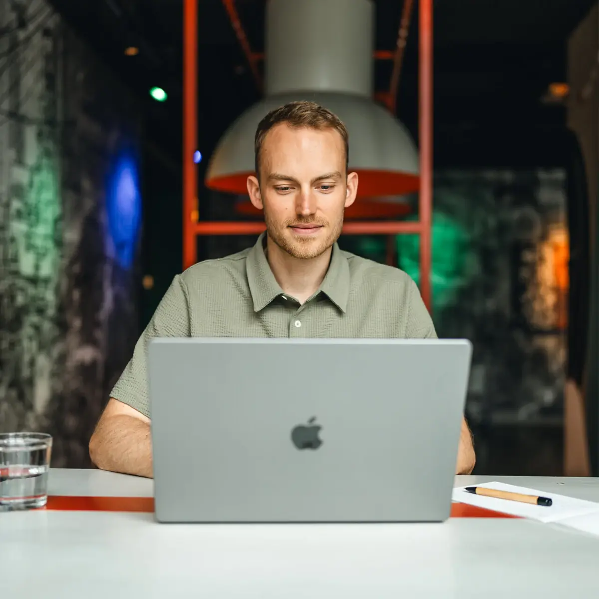 Ein Mann sitzt an einem Tisch und benutzt einen Laptop.