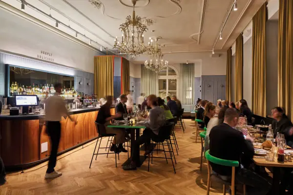 Auntie Heidi Restaurant Eine Gruppe von Menschen sitzt an Tischen in einem Restaurant.
