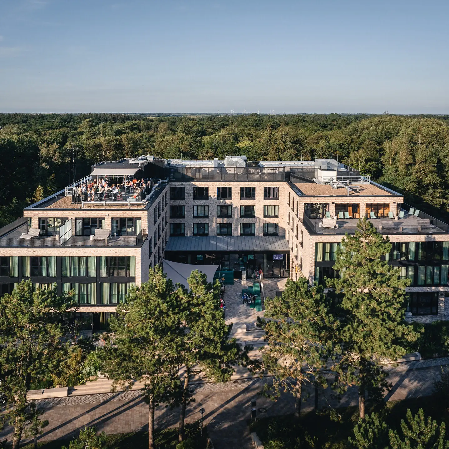 Das Urban Nature Hotel in St. Peter-Ording mit Bäumen im Hintergrund.