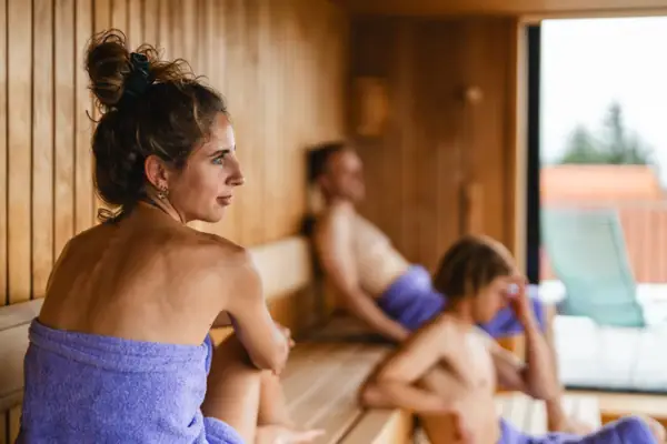 Eine Gruppe von Personen sitzt in einer Sauna.