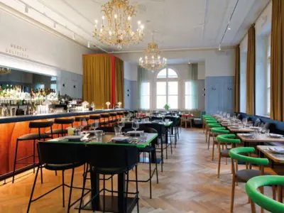 Stilvolles Restaurant mit eleganter Bar, Kronleuchtern, langen Tafeln und modernem Design