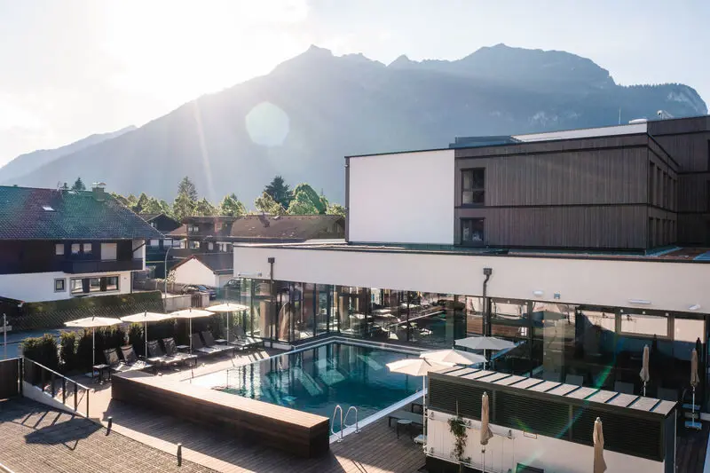 Ein Schwimmbecken in einem Gebäude mit einem Berg im Hintergrund.