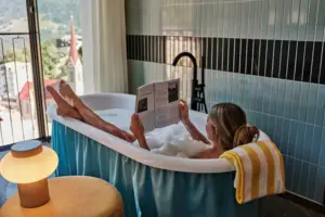 Eine Frau in einer Badewanne liest ein Buch.