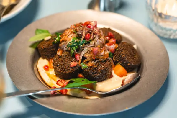 Ein Teller von oben fotografiert auf dem eine leckere Speise mit Falafel angerichtet ist.