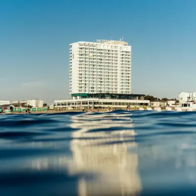 Modernes Hochhaushotel direkt am Wasser mit klarem blauen Himmel im Hintergrund