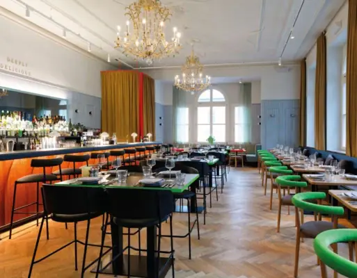 Stilvolles Restaurant mit eleganter Bar, Kronleuchtern, langen Tafeln und modernem Design
