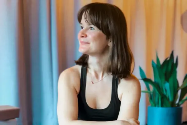 Eine Frau sitzt auf einer Yogamatte.